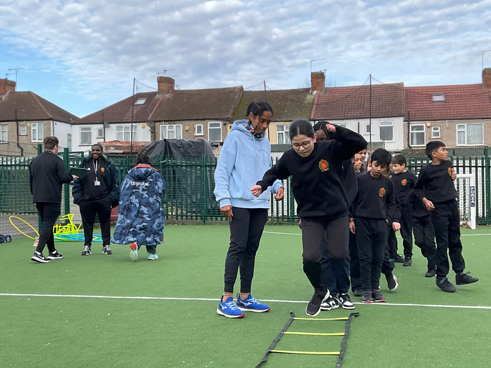 Children being shown triple jump by Yamile Aldama