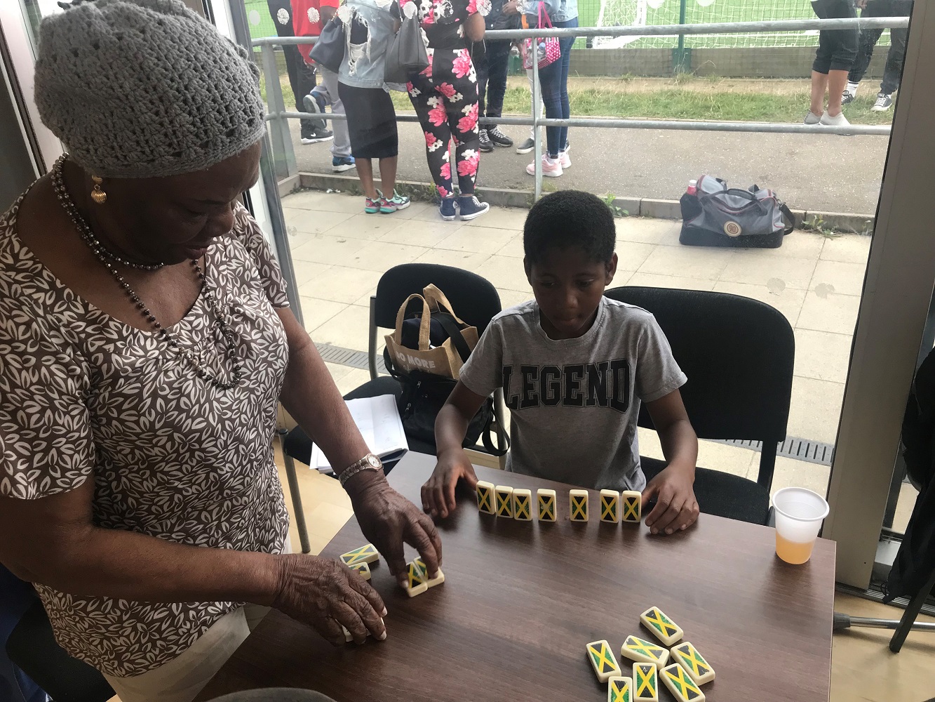Older lady and young boy playing dominoes