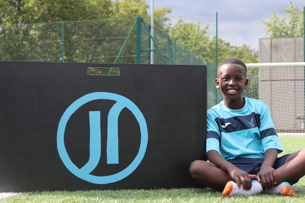 Boy in JRF Kit next to JRF Logo