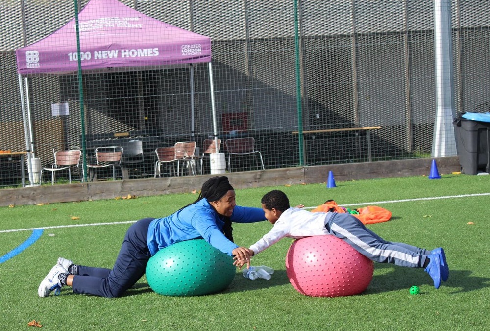 Coach and SEN child balancing on balls