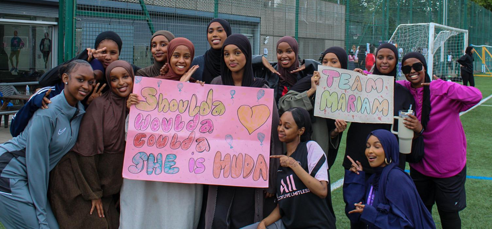 Group of girls holding homemade placards of support for their teams
